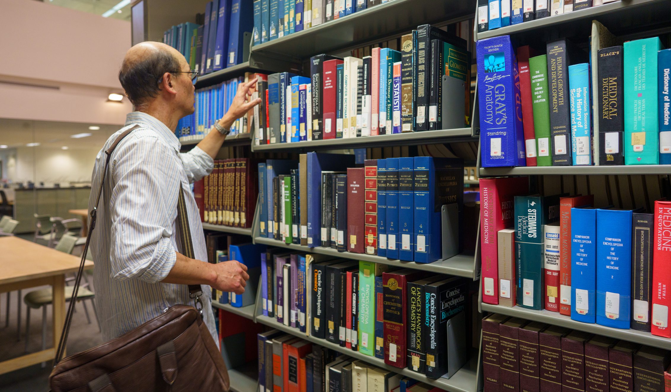 Person selecting book from shelf