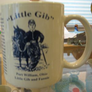 A commemorative mug honoring Little Gibs with a historical illustration.