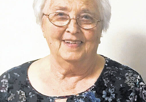 Elderly woman wearing glasses and floral blouse
